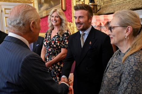King Charles III shaking hands with David Beckham at an awards ceremony.