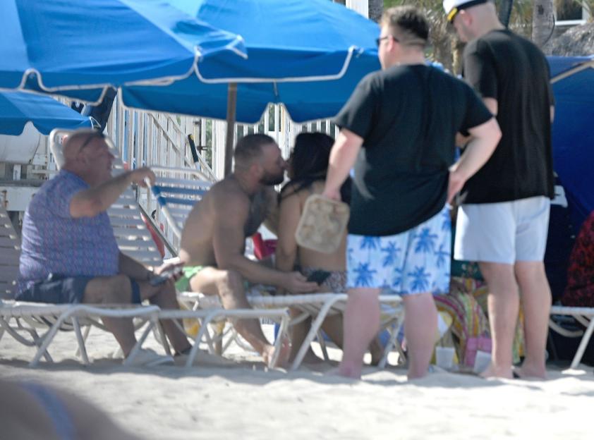 Conor McGregor kissing a woman on a beach.