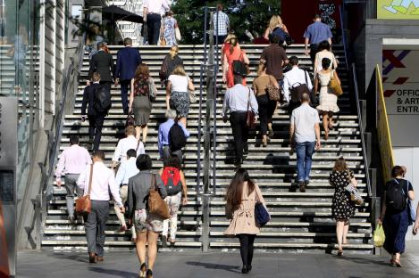 Commuters walking up a staircase.