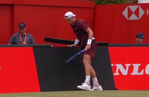 Tennis player retrieving his racket.