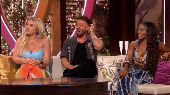 Screenshot of three people sitting on a couch during a television show.