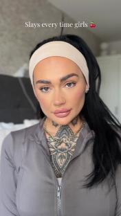 Woman with dark hair and tattoos wearing a headband and grey jacket.