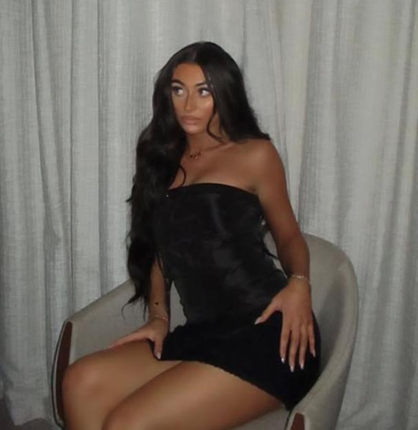 Photo of Saskia Bishop, a young woman, sitting in a chair wearing a black dress.