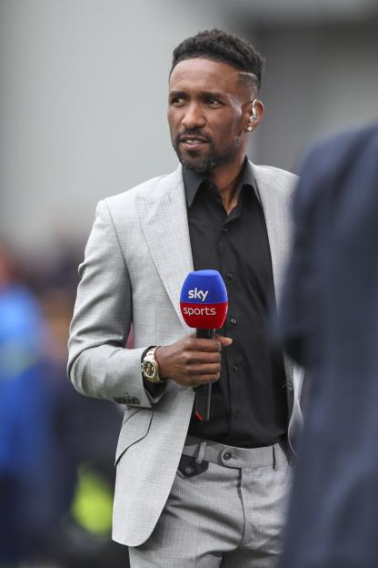 Jermaine Defoe, Sky Sports pundit, holding a microphone.