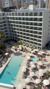 Aerial view of a Benidorm hotel with a pool and surrounding sun loungers.