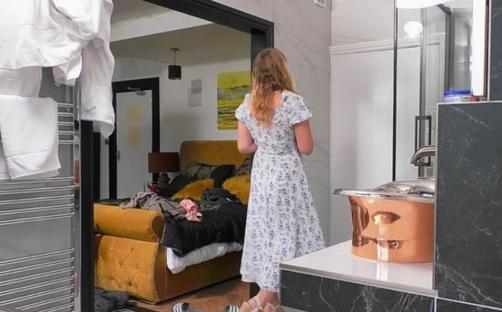 Woman in floral dress in modern bathroom.