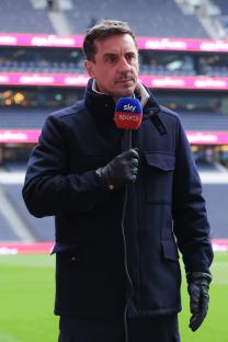 Gary Neville holding a Sky Sports microphone.