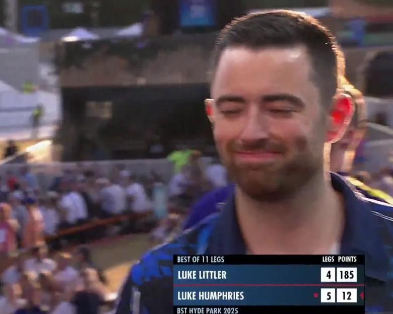 Luke Humphries smiling after a darts match, score shown.