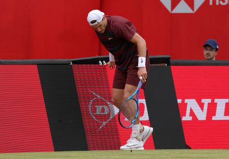 Jack Draper breaks his tennis racket during a match.