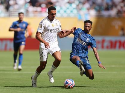 Real Madrid player tackled by Al Hilal player during a soccer match.