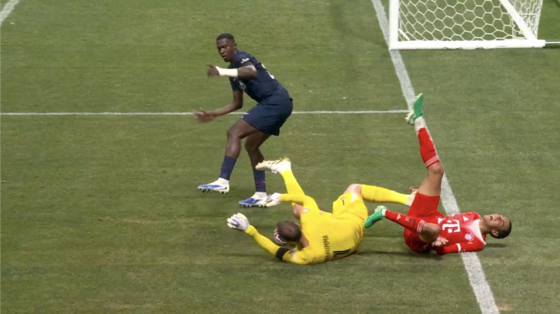 Soccer players colliding near the goal.