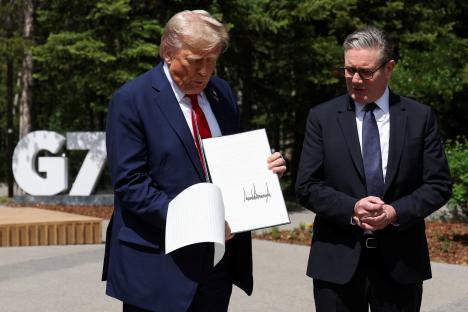 President Trump holding a signed trade agreement with the British Prime Minister.