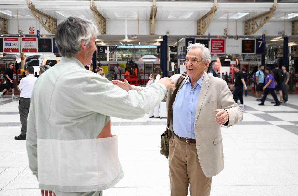 Larry Lamb and his son George Lamb embracing at a train station.