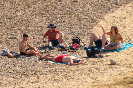 Four people relaxing on a beach.