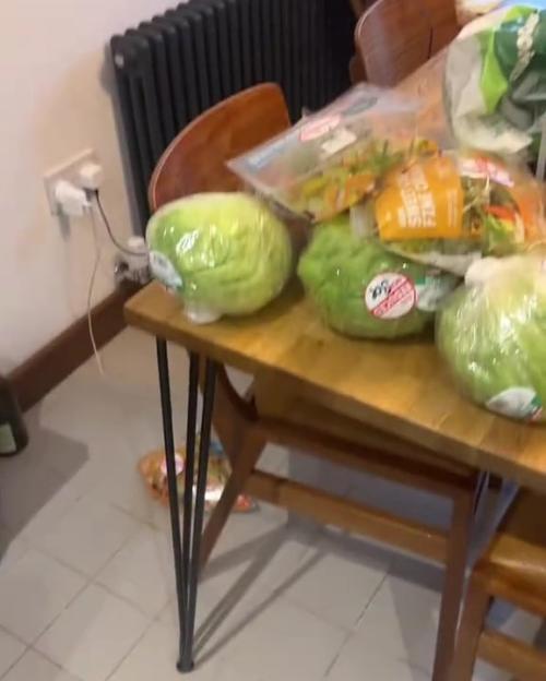 A table laden with bagged salad and lettuce.