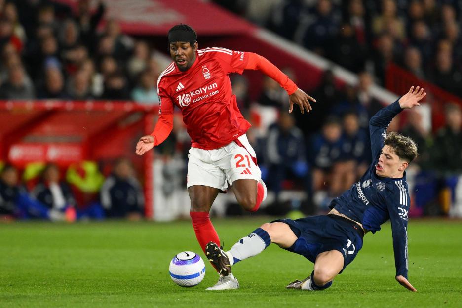 Soccer players tackling during a game.