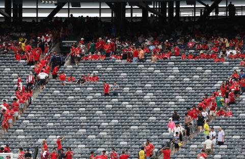 Fans returning to their seats in a stadium after a weather delay.