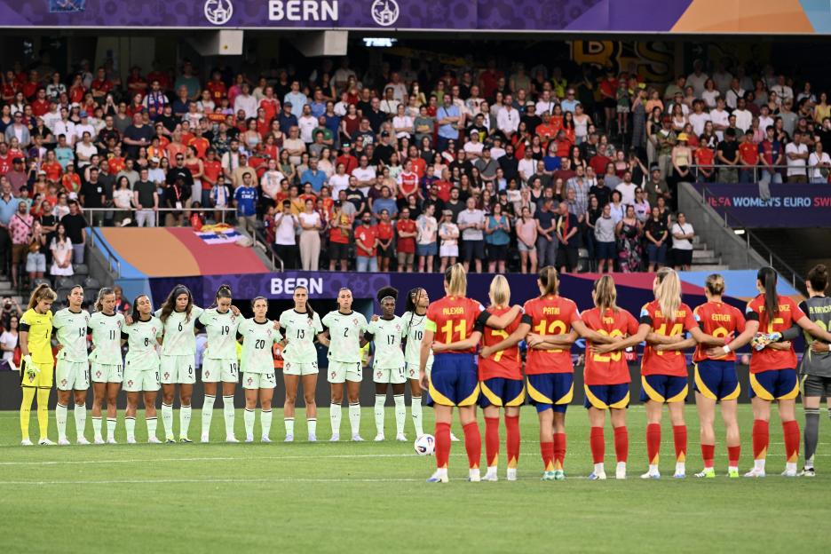 Spain and Portugal women's football teams observing a minute of silence.