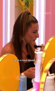 Screenshot from Love Island showing a woman applying makeup while saying,