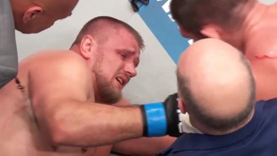 A crying fighter being examined by medical personnel.