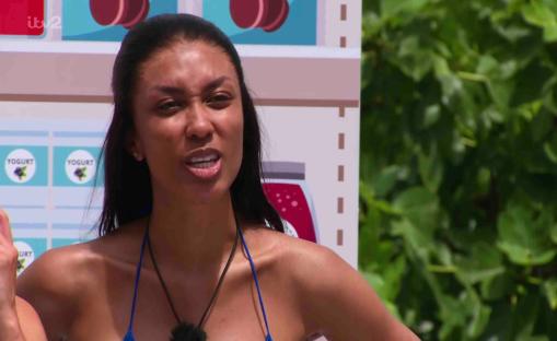 Still image of a woman in a blue bikini top, looking upset.