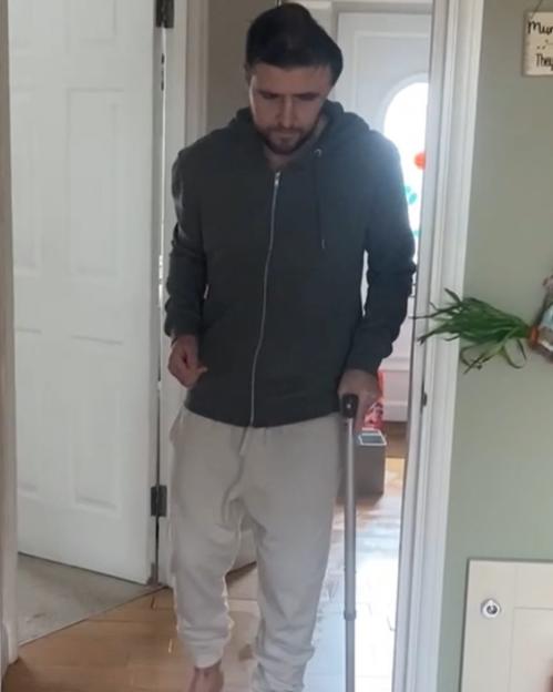 Man walking with a cane indoors.