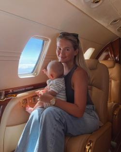 Woman holding baby on private jet.