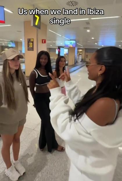 Four women at an airport in Ibiza, celebrating being single.