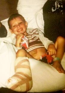 Young boy in hospital bed with leg cast.