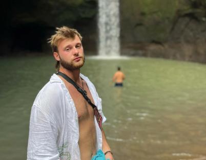 Man standing near a waterfall.
