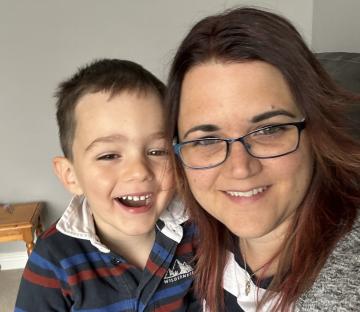 A mother and her young son smile for a photo.