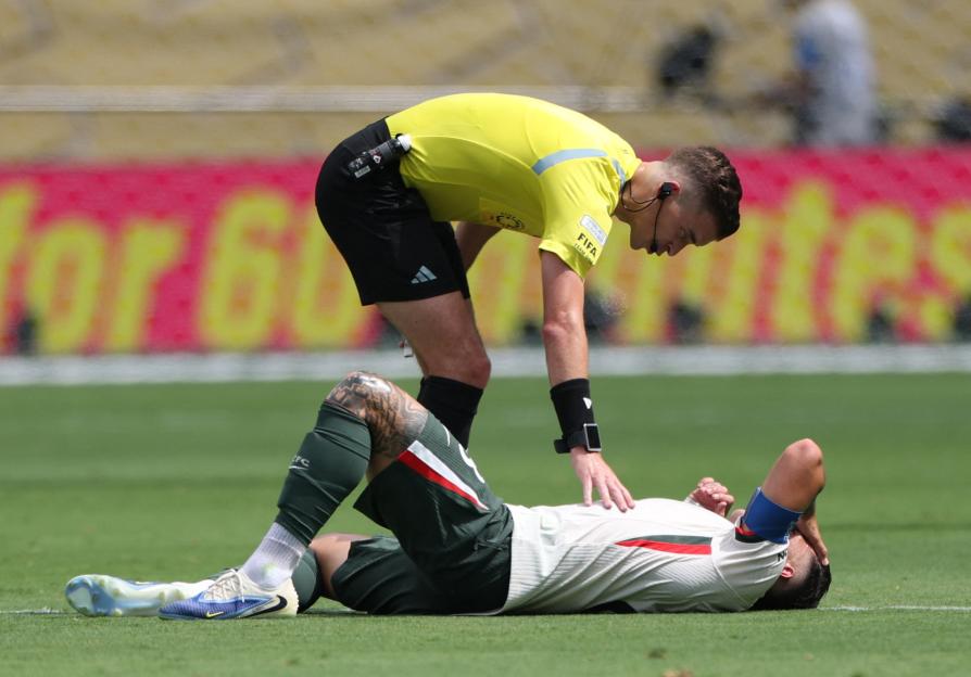 Referee attending to injured Chelsea's Enzo Fernandez.