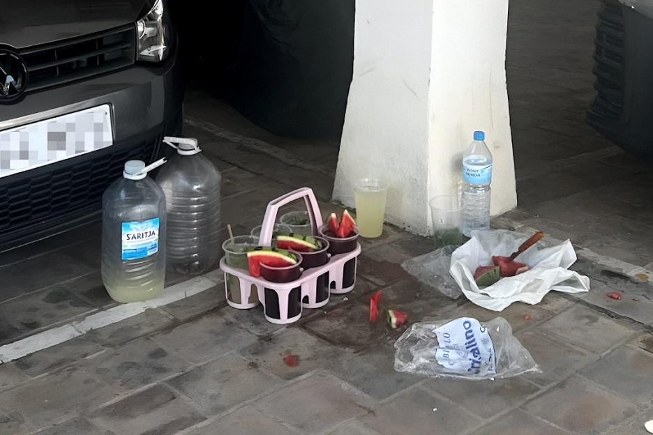 Photo of unsanitary preparation of cocktails on a parking lot floor.