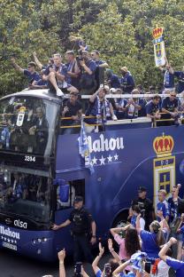 Real Oviedo players celebrating their promotion with fans on a bus.
