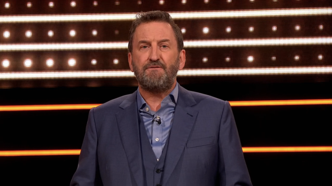 Screenshot of a man in a suit.