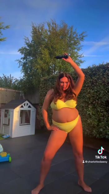 Woman in yellow bikini holding up a tanning product.