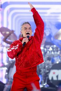 Robbie Williams performing on stage.