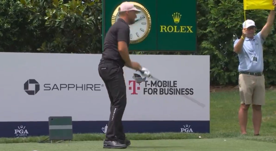 Golfer teeing off on a golf course.