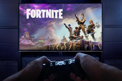 Person playing Fortnite: Save the World on a Playstation.