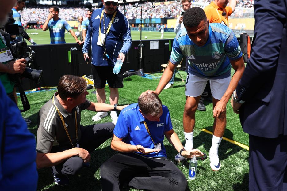 Kylian Mbappé comforts a volunteer injured by a ball.