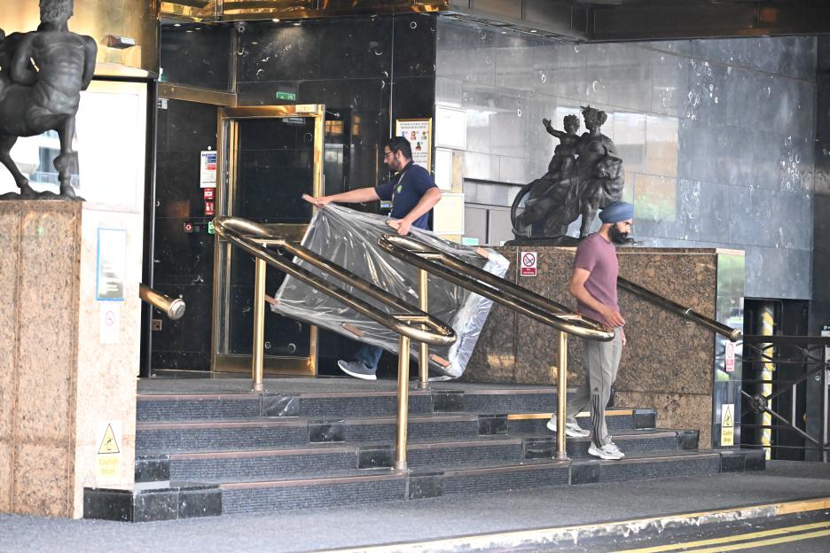 Two men moving beds into a hotel.