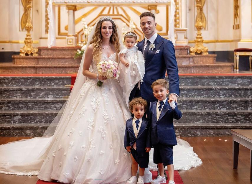 Wedding photo of a couple with their children in a church.