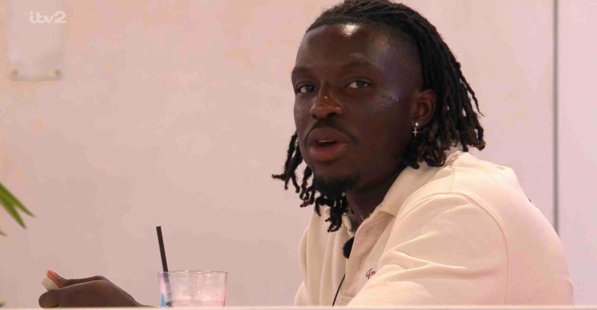 Dejon from Love Island, seated and talking.
