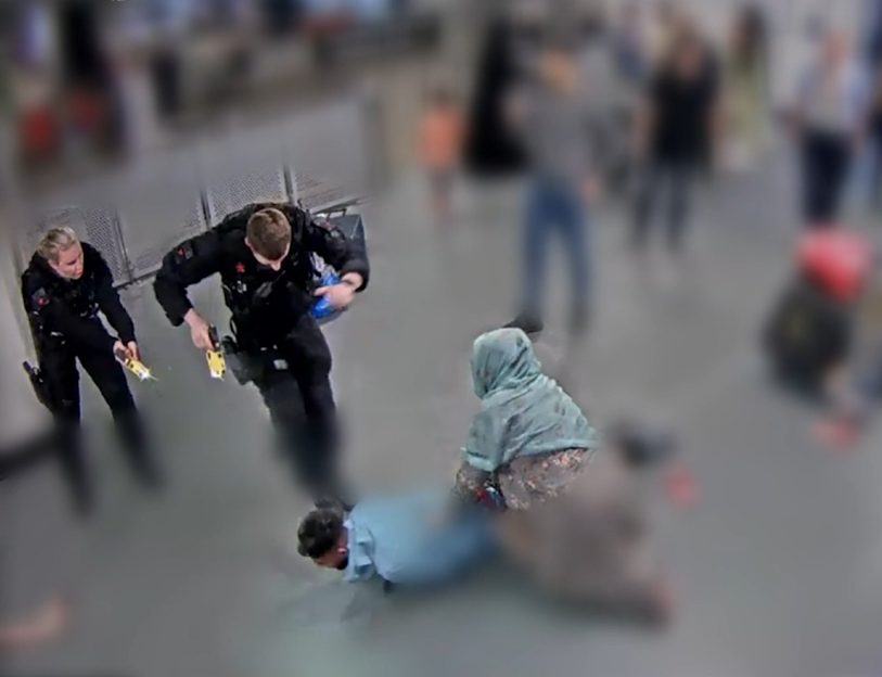 Airport security officers apprehending a person.