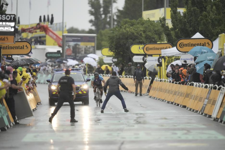 Cyclist approaching the finish line in the rain.