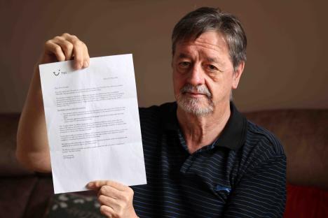 Man holding letter explaining TUI holiday cancellation.