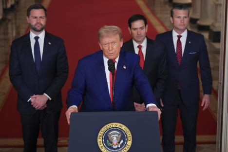 President Trump addresses the media with aides.