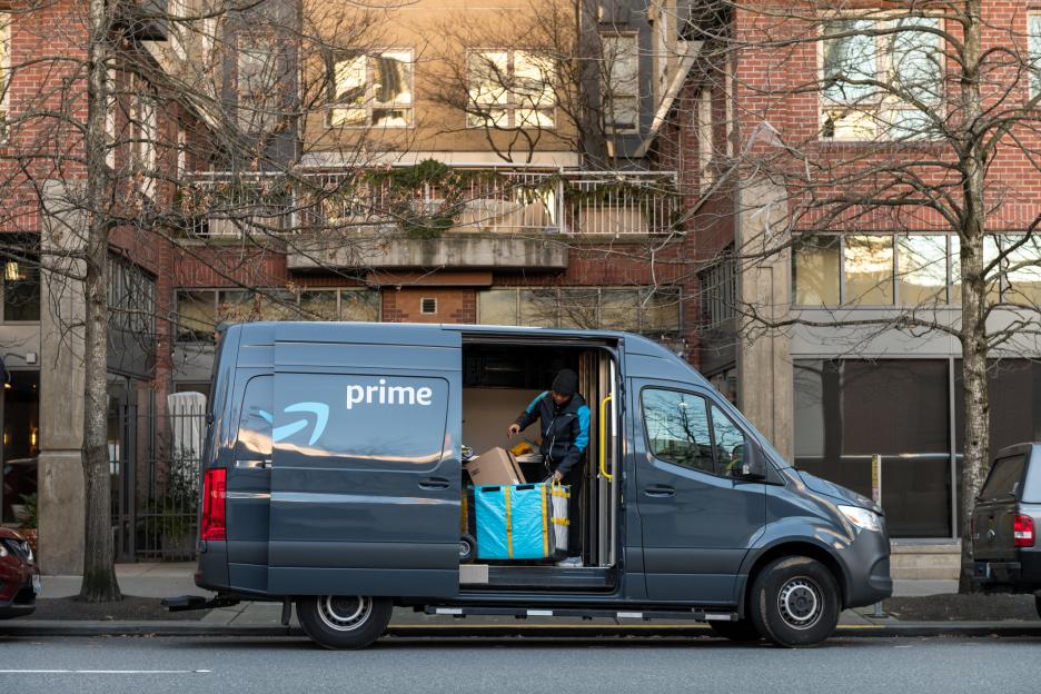 Amazon Prime Now delivery van parked on city street.