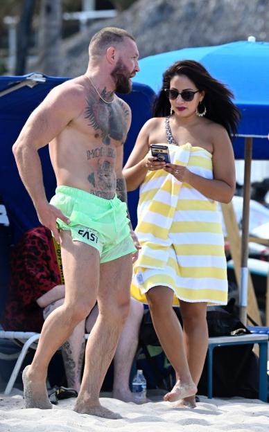 Conor McGregor on a beach with a woman.