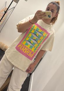 Person wearing a cream-colored shirt with a graphic of fish on it.